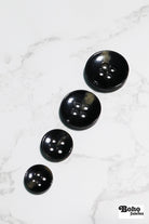 Black Tortoiseshell Round Plastic Four Hole Buttons. Available in 15mm (24L), 18mm (28L), 20mm (32L), and 28mm (44L) - Boho Fabrics - Buttons & Snaps